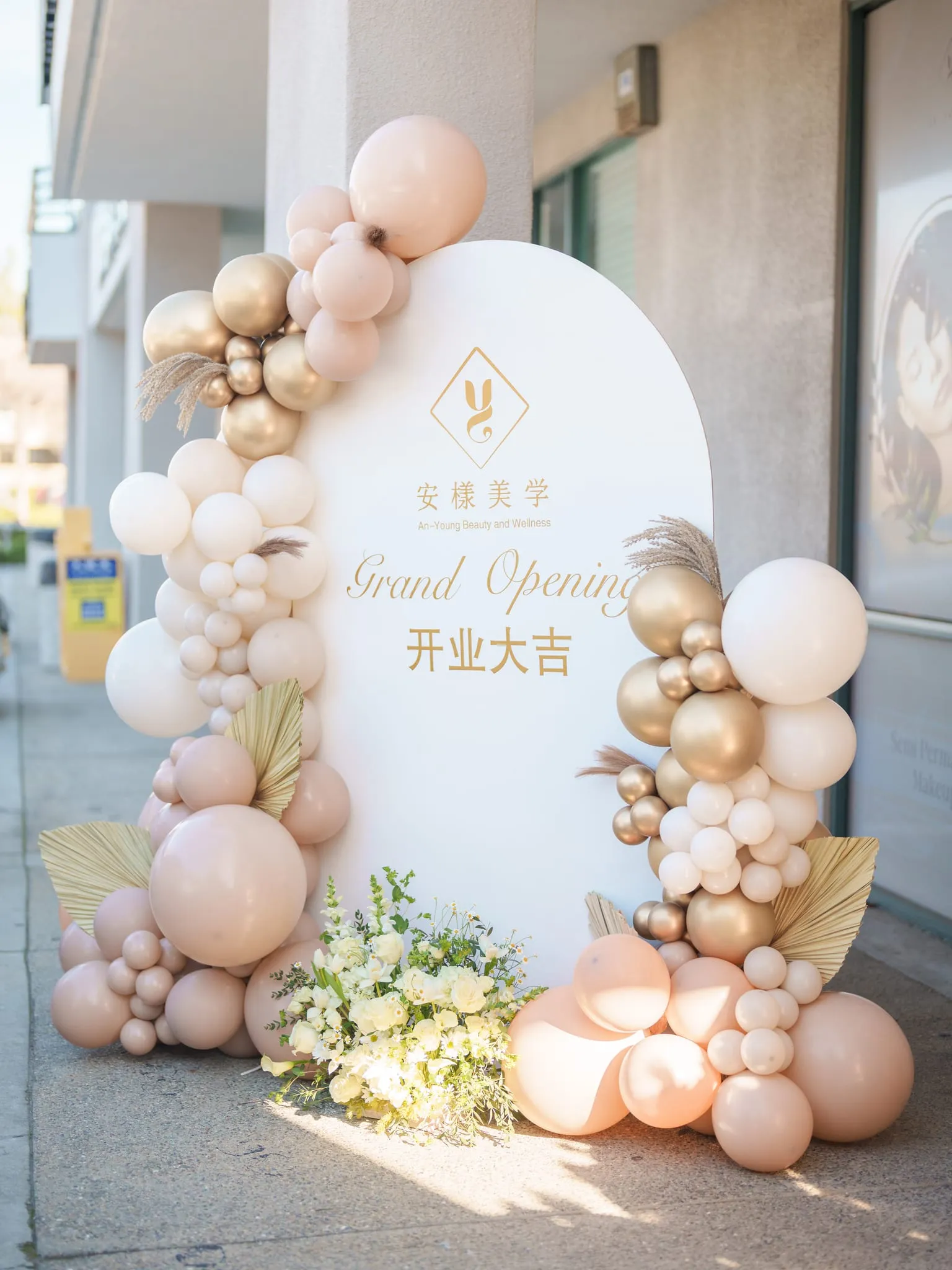 圣何塞一家美学工作室门前,粉金气球拱门环绕着开业背景板